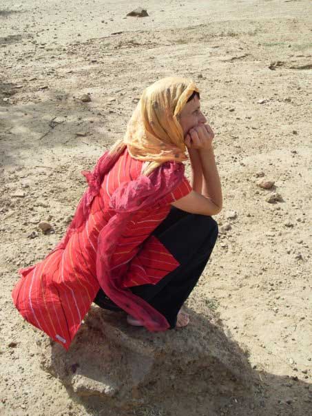 a woman kneeling on a rock of thar