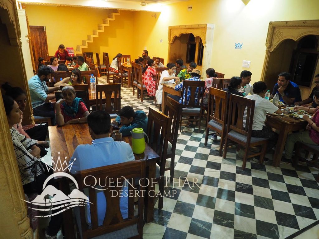 a group of people sitting at tables in a restaurant